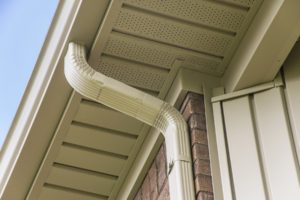 Seamless Gutters and downspout near the roof of a house.